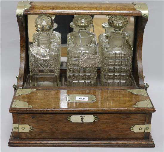 An Edwardian oak three bottle tantalus